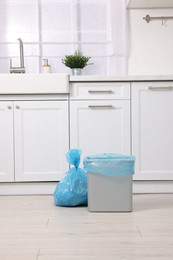 Photo of Plastic garbage bag and trash can in kitchen