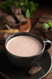 Photo of Cup of delicious hot cocoa on wooden table, closeup