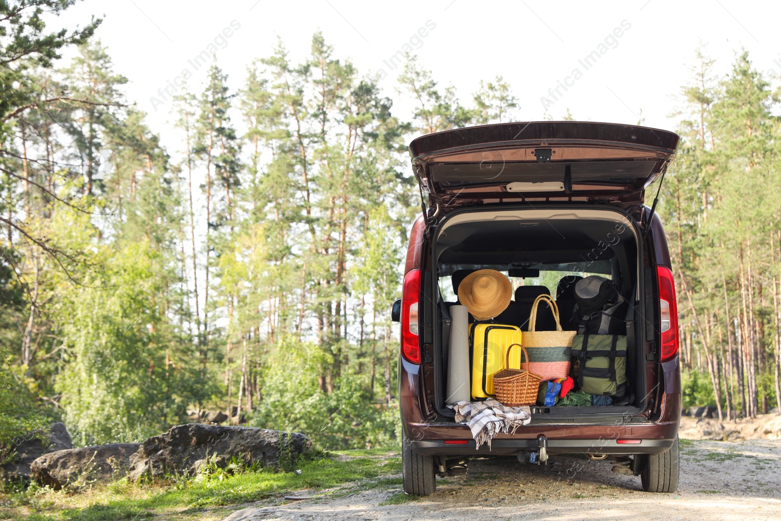 Photo of Van with camping equipment in trunk outdoors