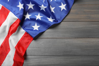 Photo of American flag on wooden table, top view. Space for text