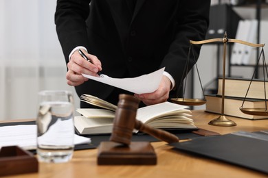 Photo of Lawyer working with document at wooden table, closeup