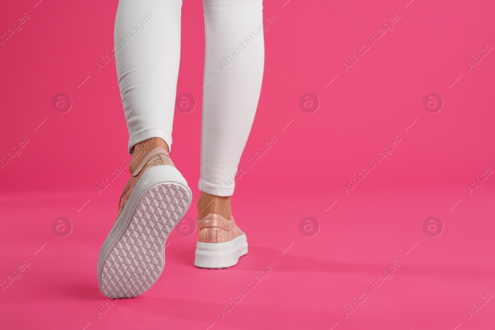 Photo of Woman wearing shoes on pink background, closeup. Space for text