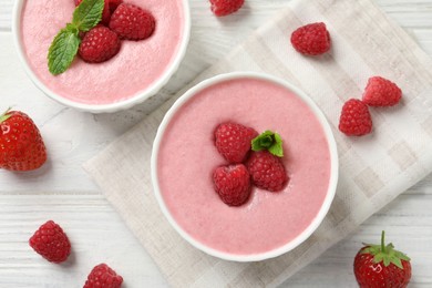 Photo of Delicious raspberry mousse with mint on white wooden table, flat lay