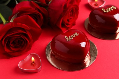 Photo of St. Valentine's Day. Delicious heart shaped cakes and roses on red background, closeup