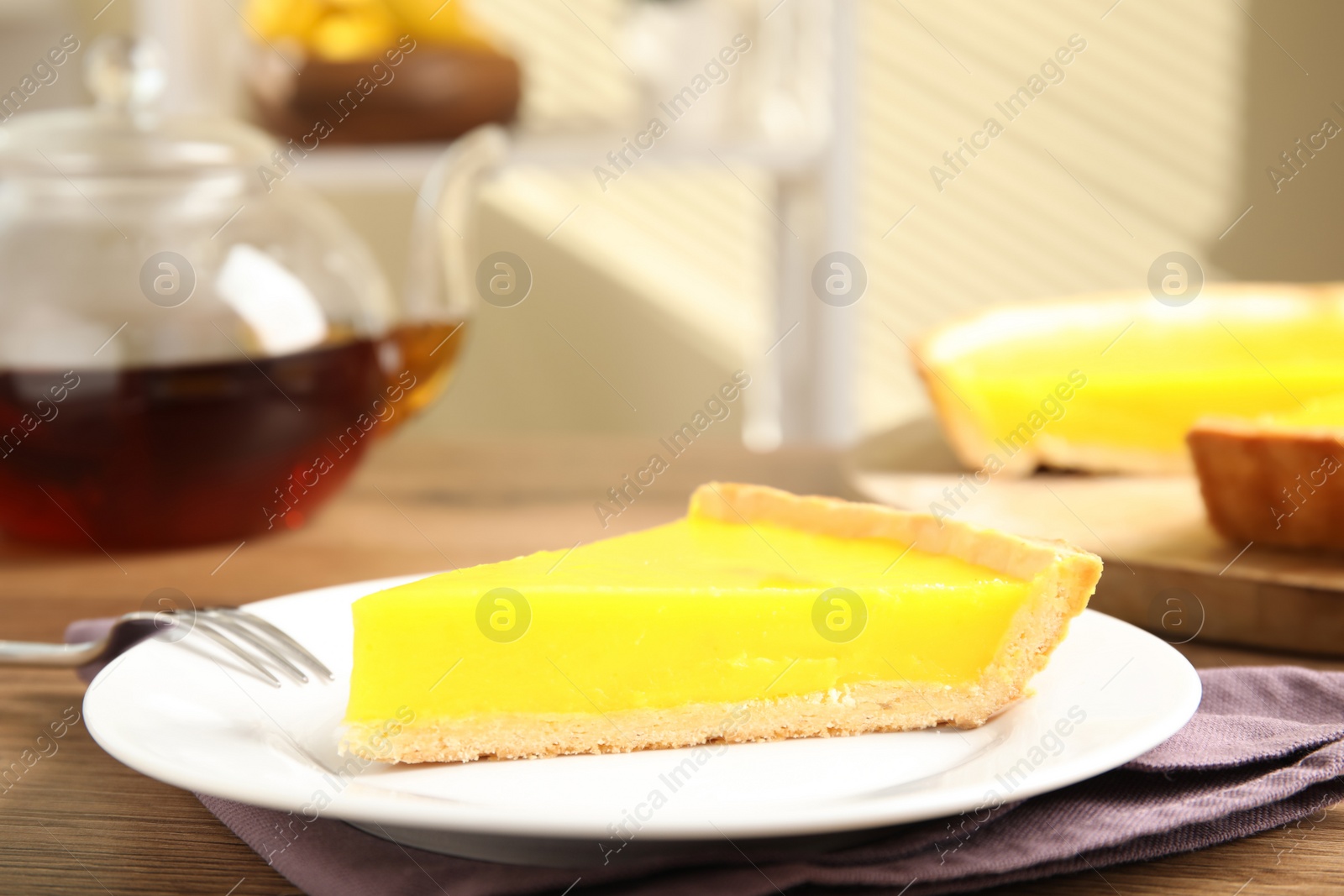 Photo of Slice of delicious homemade lemon pie on wooden table