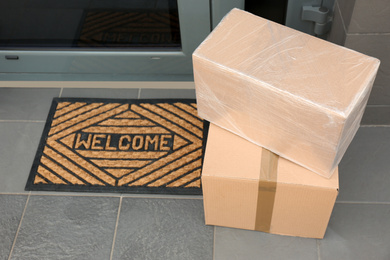 Photo of Cardboard boxes near door. Parcel delivery service