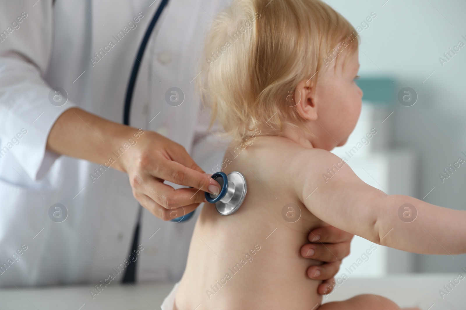 Photo of Pediatrician examining baby with stethoscope in hospital. Health care