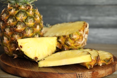 Photo of Slices of fresh pineapple on wooden board, closeup