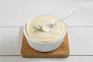 Photo of Fresh mayonnaise sauce in bowl on white wooden table