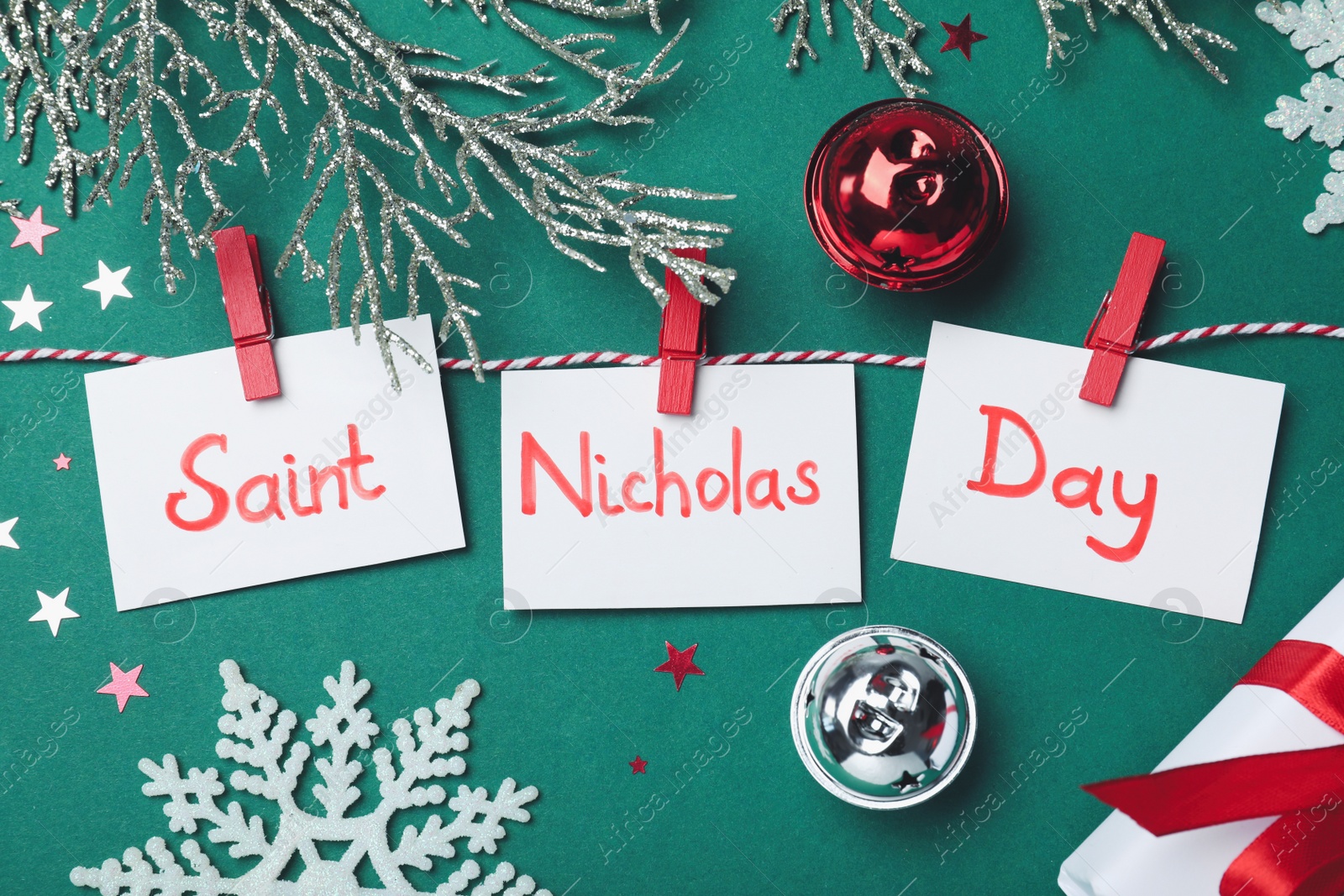 Photo of Saint Nicholas Day. Rope with paper notes and festive decor on green background, flat lay