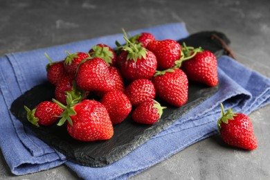 Photo of Many delicious ripe strawberries on grey table