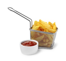 Photo of Delicious French fries in metal basket and ketchup isolated on white