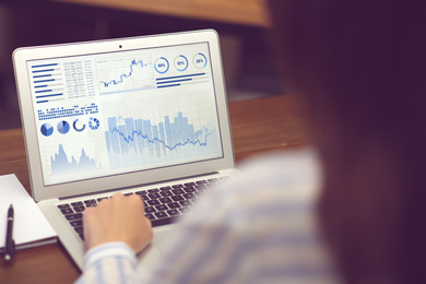 Image of Woman working on modern laptop at table, closeup. Fintech concept