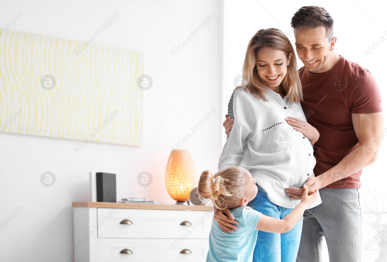 Photo of Young pregnant woman with her family at home