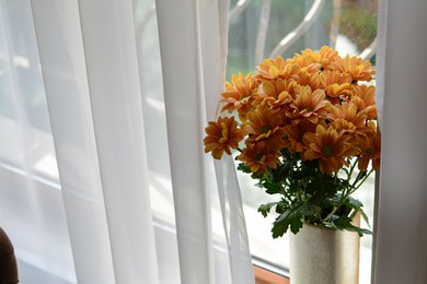 Photo of Bouquet of beautiful chrysanthemum flowers in vase near window indoors. Space for text