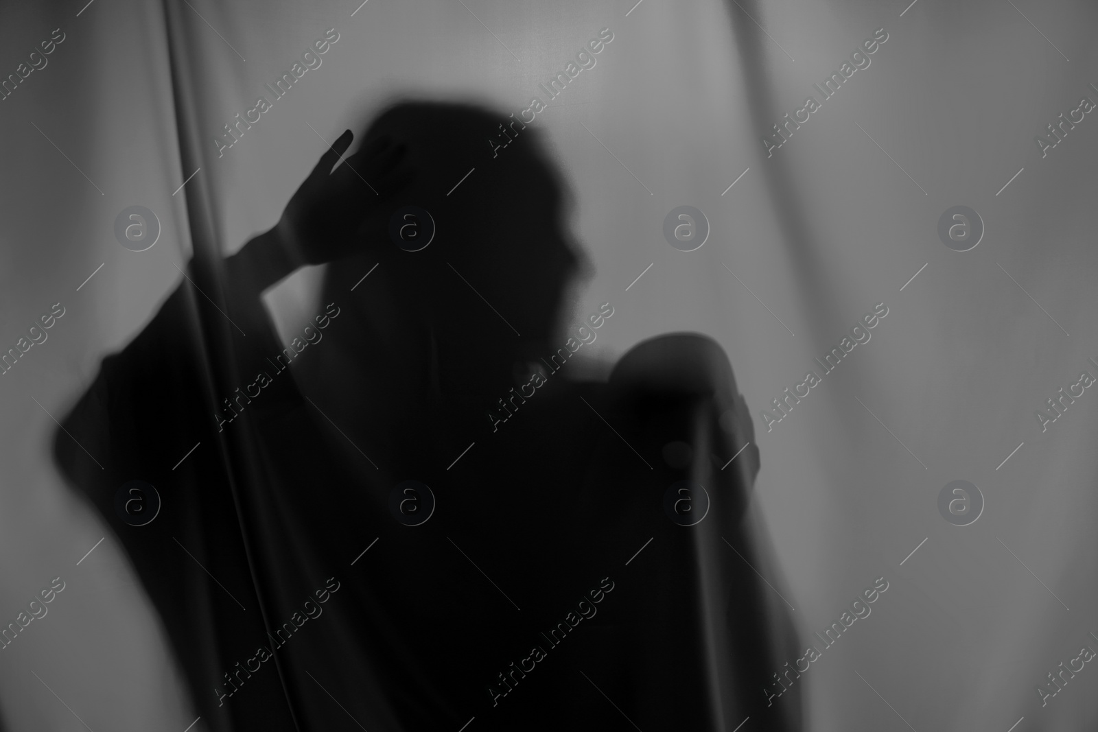 Photo of Silhouette of creepy ghost with skull behind grey cloth, space for text