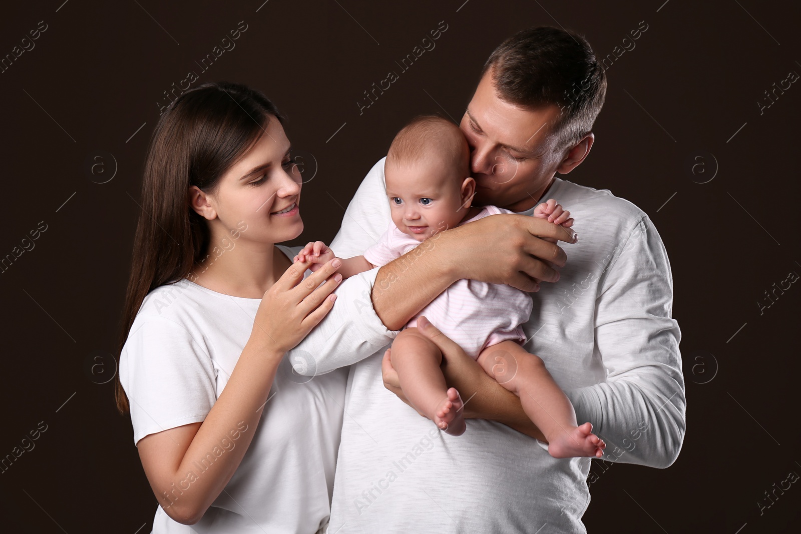 Photo of Happy family with little baby on dark background