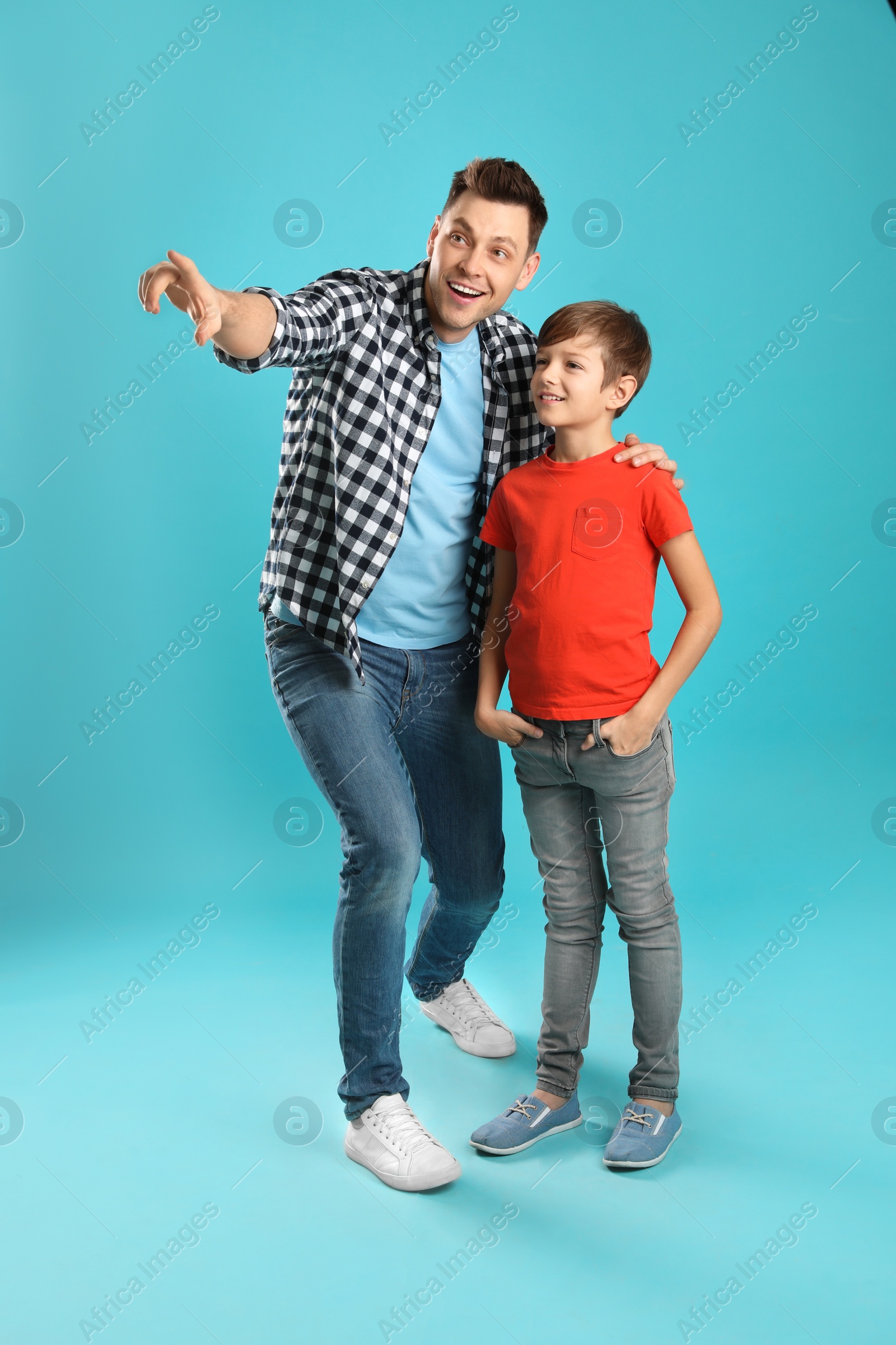 Photo of Portrait of dad and his son on color background