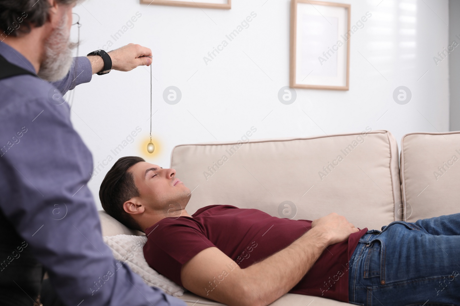 Photo of Psychotherapist using pendulum during hypnotherapy   session in office