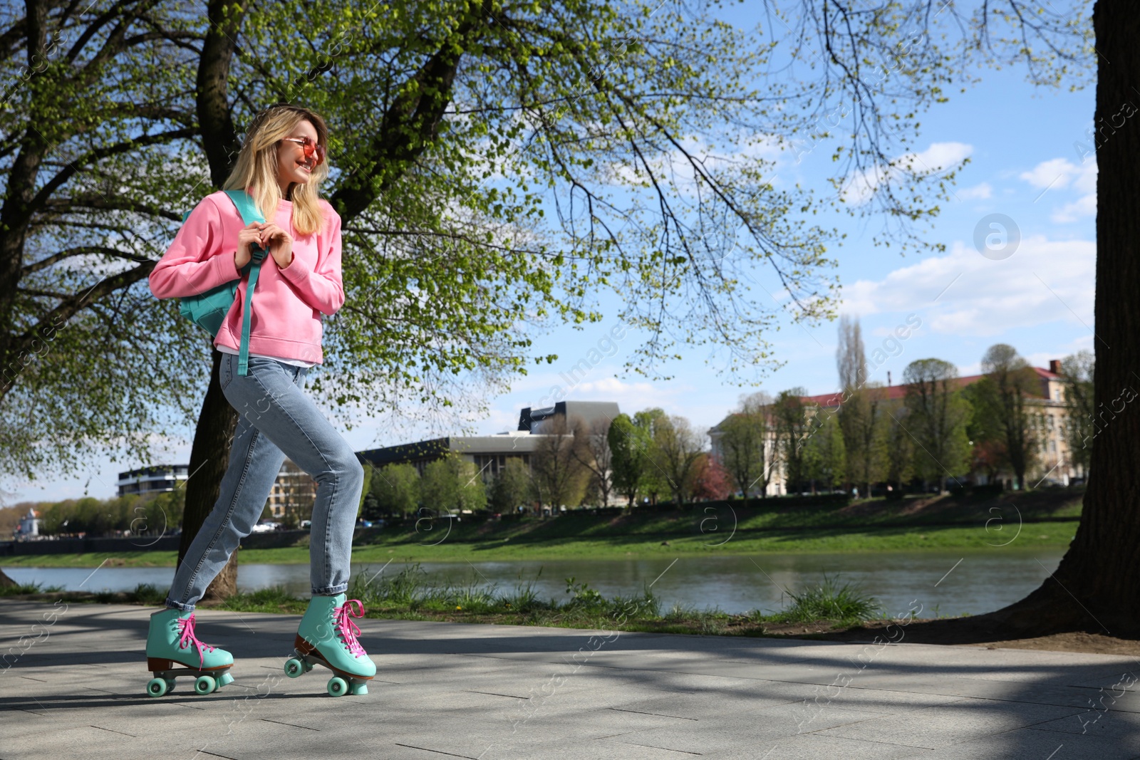 Photo of Beautiful young woman roller skating outdoors on sunny day