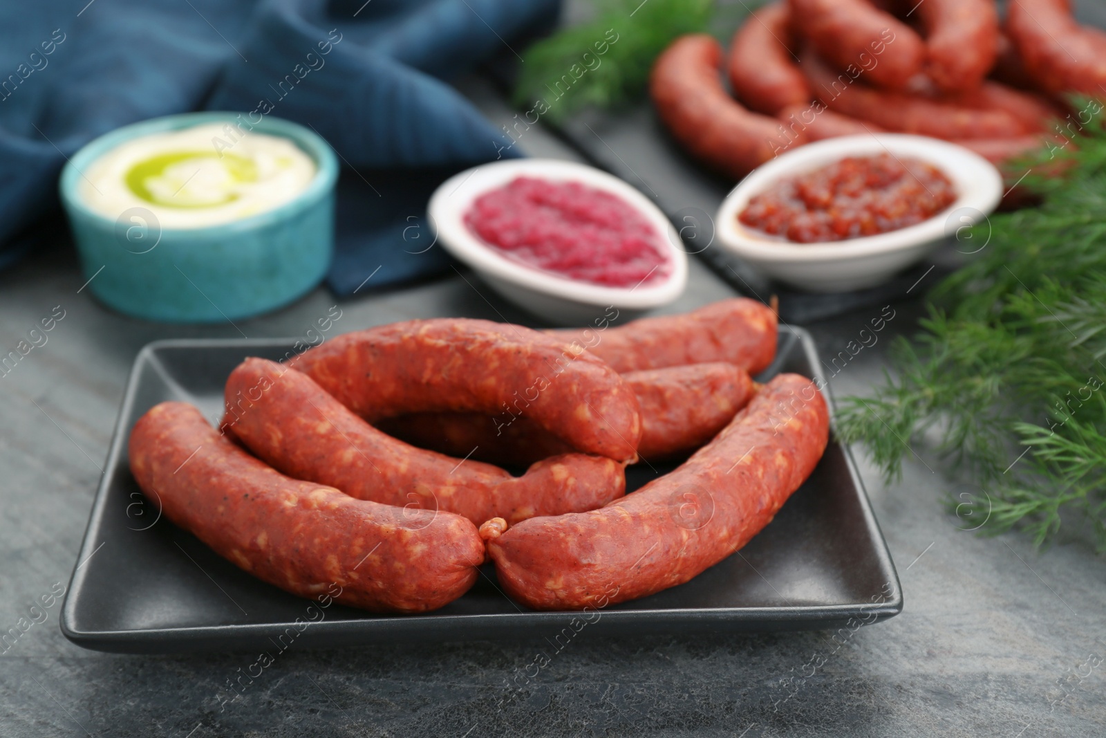 Photo of Tasty sausages served on black table, closeup. Meat product