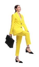 Beautiful businesswoman in yellow suit with briefcase posing on white background