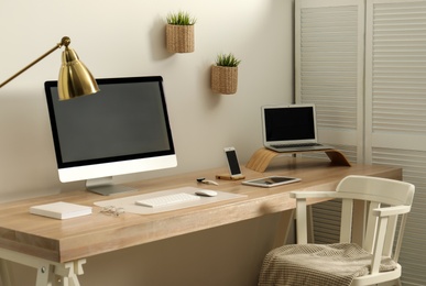 Stylish workplace interior with modern computer on table. Mockup for design