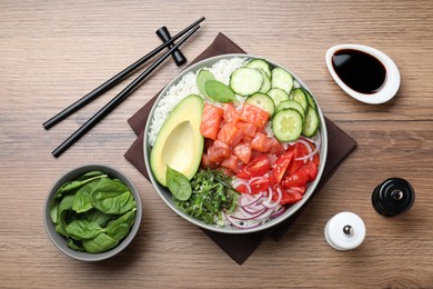 Delicious poke bowl with salmon and vegetables served on wooden table, flat lay