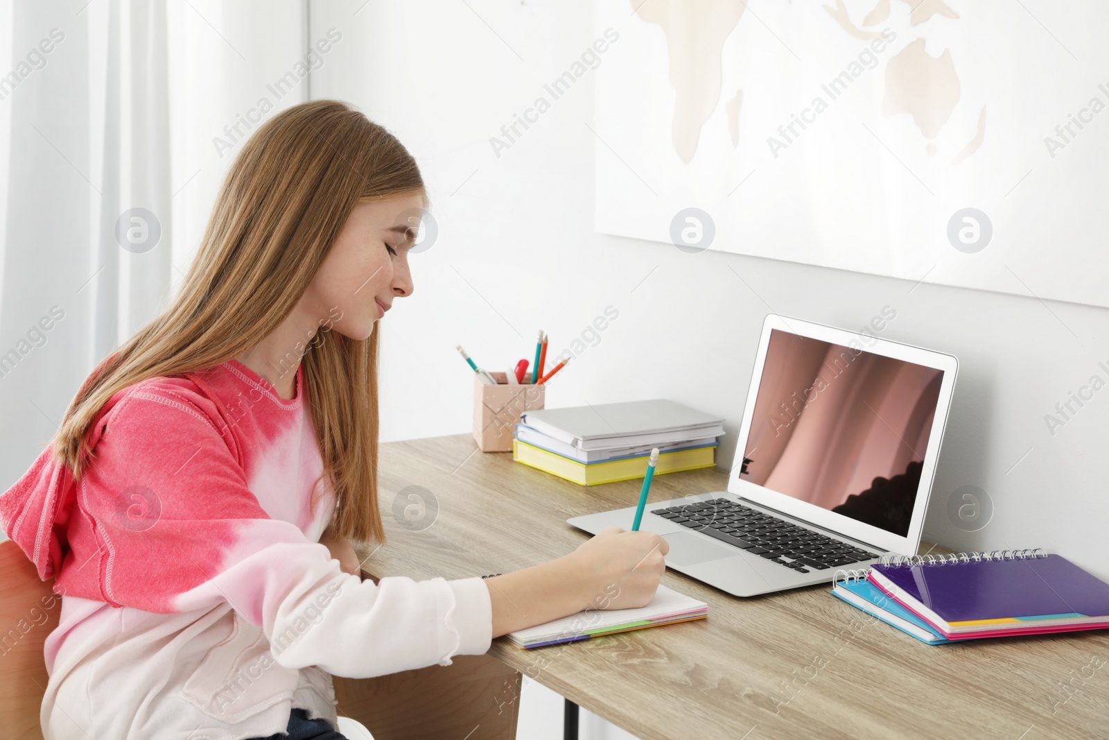 Photo of Teenager girl doing her homework at desk