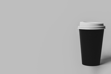 Photo of Takeaway paper coffee cup on light grey background. Space for text