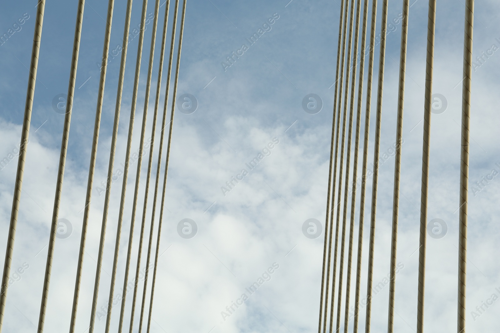 Photo of Modern bridge cables against blue sky, low angle view