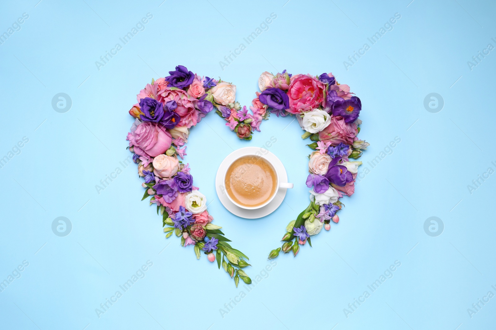 Photo of Beautiful heart shaped floral composition with cup of coffee on turquoise background, flat lay