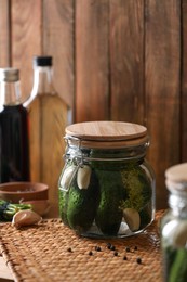 Photo of Glass jar with cucumbers, dill and garlic on wooden table. Canning vegetable