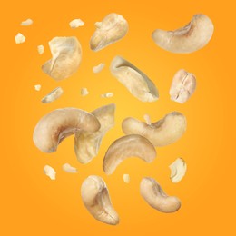 Image of Tasty cashew nuts flying on yellow background