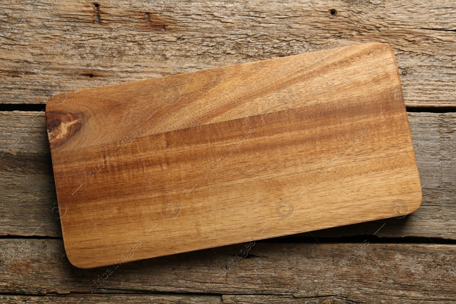 Photo of One new cutting board on old wooden table, top view