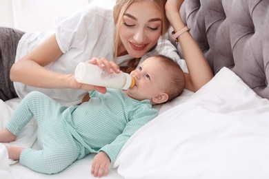 Photo of Woman feeding her child in bedroom. Healthy baby food