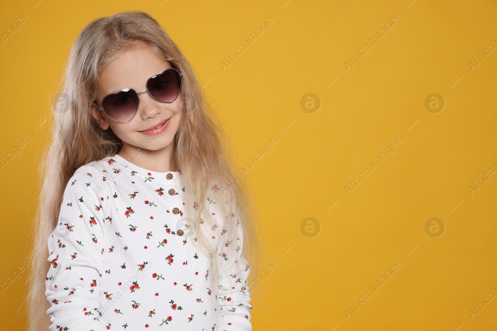 Photo of Girl wearing stylish sunglasses on orange background, space for text