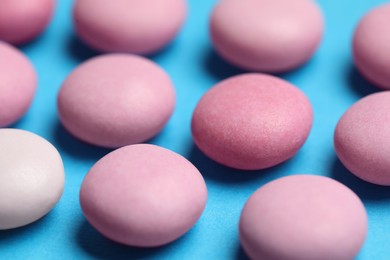 Photo of Pink bubble gums on blue background, closeup