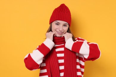 Photo of Beautiful woman in warm scarf on yellow background