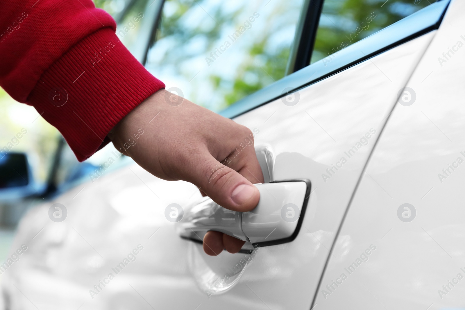 Photo of Closeup view of man opening car door outdoors