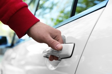 Photo of Closeup view of man opening car door outdoors