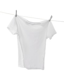 Photo of One t-shirt drying on washing line isolated on white