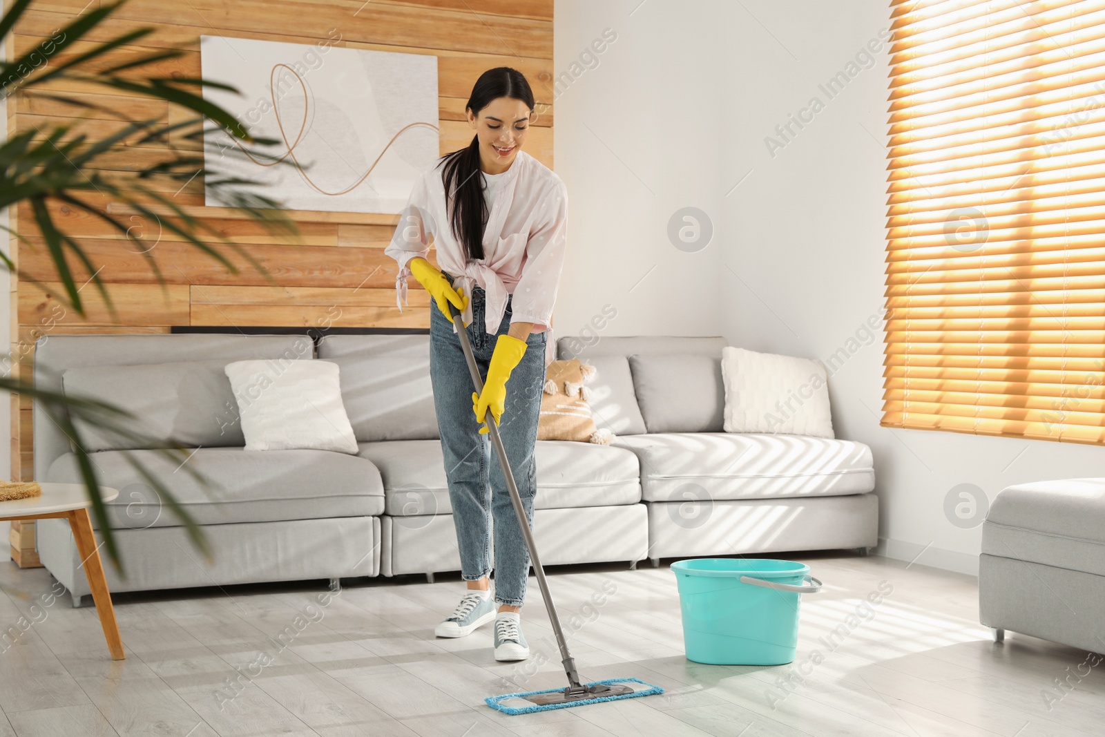 Photo of Woman cleaning floor with mop at home