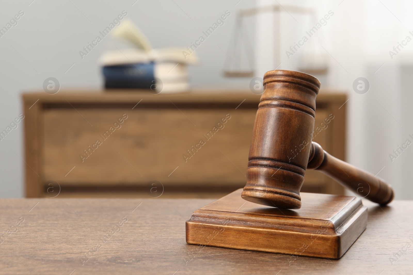 Photo of Wooden gavel and sound block on table indoors, closeup. Space for text