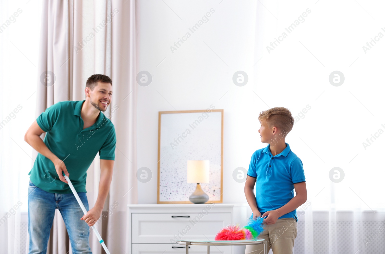 Photo of Dad and son cleaning living room together