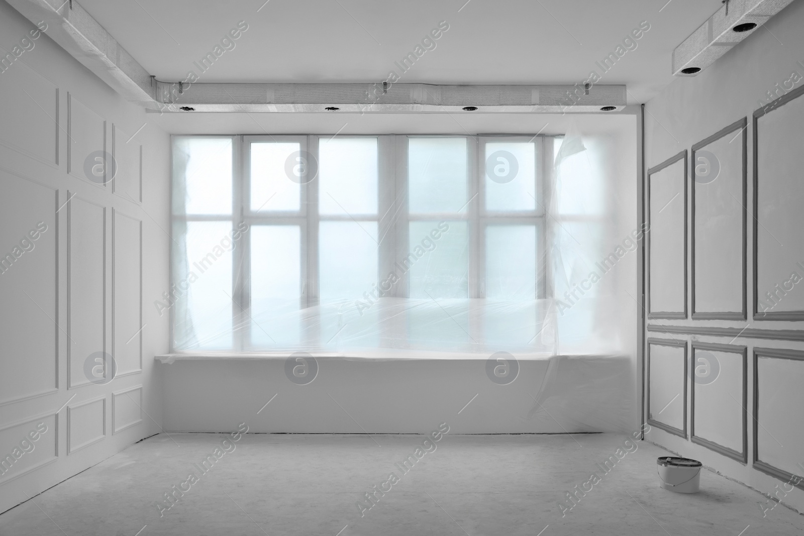 Photo of Window covered by plastic film in room with fresh painted walls