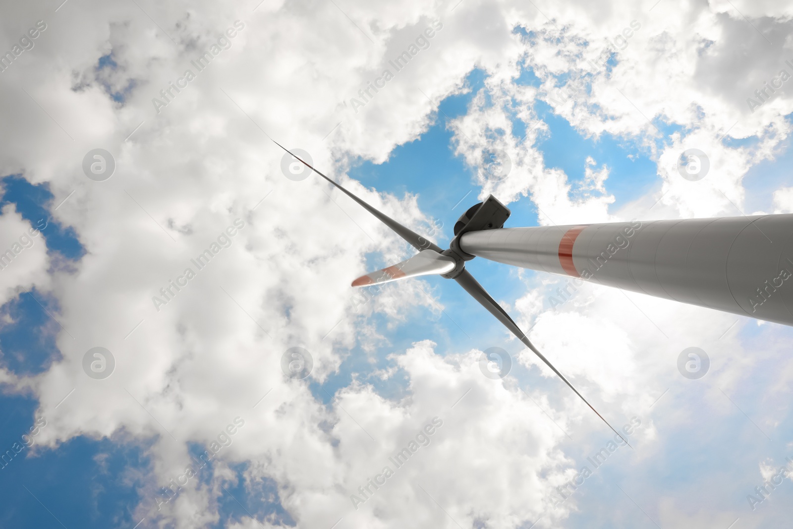 Photo of Modern wind turbine against cloudy sky, low angle view. Alternative energy source