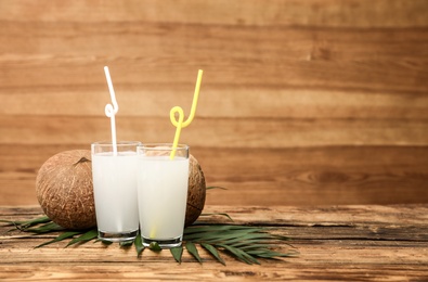Composition with glasses of coconut water on wooden background. Space for text