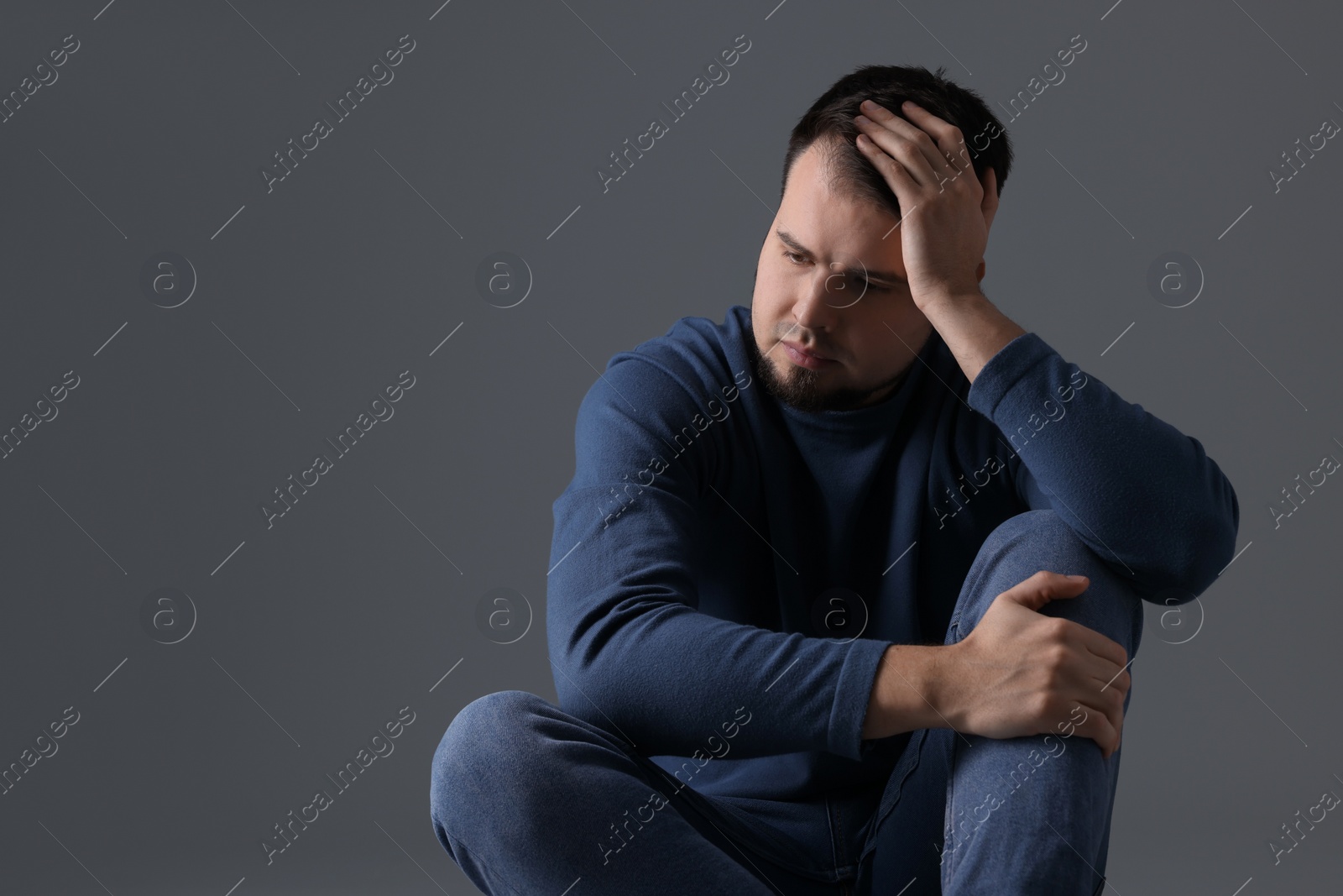 Photo of Portrait of sad man on dark grey background