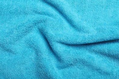 Crumpled light blue microfiber cloth as background, closeup